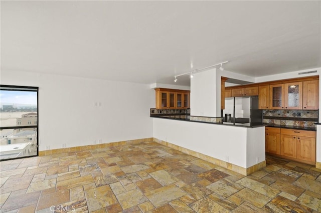 1750 E Ocean Blvd Unit 511, Long Beach, CA 90802 - kitchen featuring fridge with ice dispenser, stone tile flooring, tasteful backsplash, dark countertops, and track lighting
