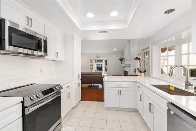 18 Blazing Star, Irvine, CA 92604 - kitchen featuring appliances with stainless steel finishes, a sink, light tile patterned flooring, open floor plan, and a raised ceiling