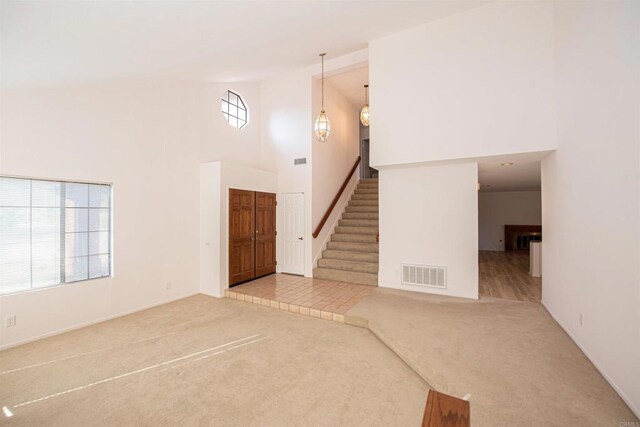 2432 Live Oak Rd, Escondido, CA 92029 - unfurnished living room with carpet floors, a high ceiling, and stairs