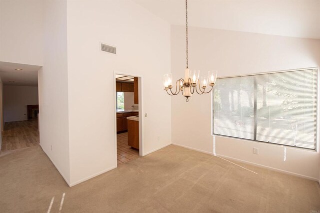 2432 Live Oak Rd, Escondido, CA 92029 - empty room with light colored carpet, high vaulted ceiling, a chandelier, and baseboards