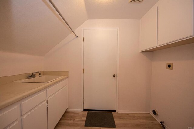 2432 Live Oak Rd, Escondido, CA 92029 - laundry room with hookup for an electric dryer, cabinet space, light wood-style floors, and baseboards