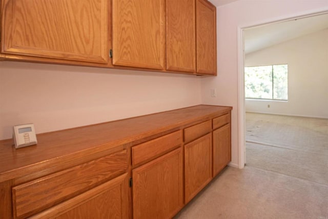 2432 Live Oak Rd, Escondido, CA 92029 - kitchen featuring light carpet, lofted ceiling, and brown cabinetry