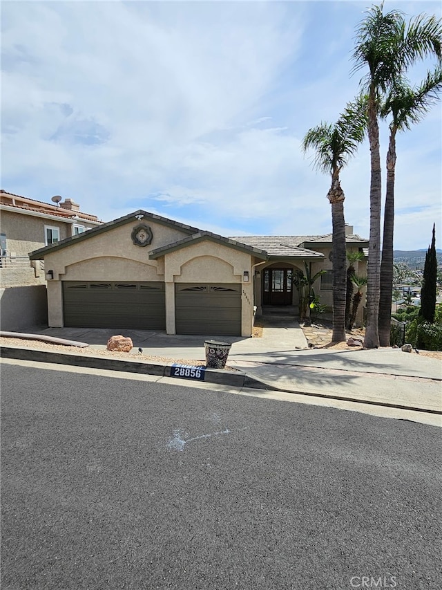 28856 Yosemite Pl, Canyon Lake, CA 92587 - view of front of property with an attached garage, stucco siding, and driveway