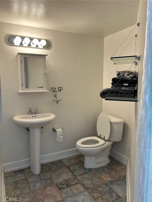 28856 Yosemite Pl, Canyon Lake, CA 92587 - bathroom with stone finish flooring, toilet, baseboards, and a sink