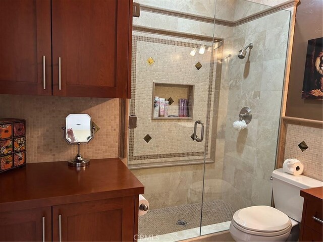 28856 Yosemite Pl, Canyon Lake, CA 92587 - bathroom featuring tile walls, toilet, a stall shower, vanity, and decorative backsplash