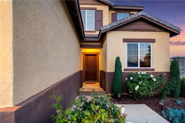 view of exterior entry with stucco siding