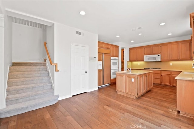 5176 Glenview St, Chino Hills, CA 91709 - kitchen featuring white appliances, a center island with sink, light countertops, light wood-type flooring, and recessed lighting