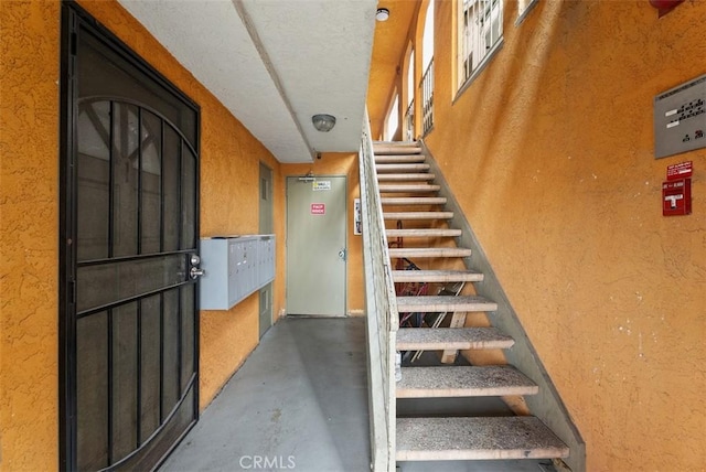 1061 Dawson Ave, Long Beach, CA 90804 - staircase featuring concrete floors and a textured wall