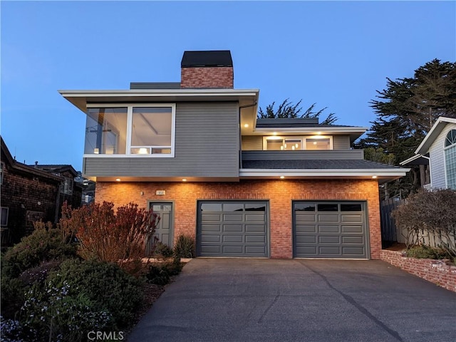 1850 Laurel Pl, Cambria, CA 93428 - view of front facade with driveway, a chimney, a garage, and brick siding