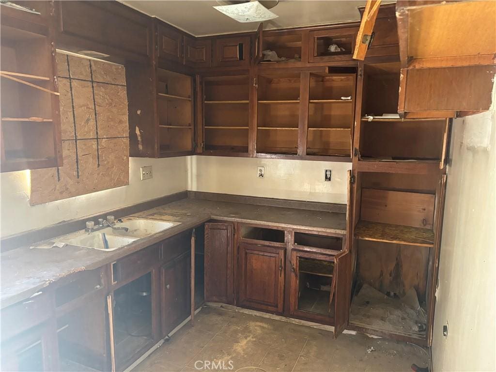 482 E Smith St, Long Beach, CA 90805 - kitchen featuring a sink, open shelves, and dark brown cabinets