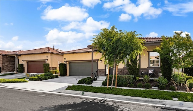 4699 S Moneta Privado, Ontario, CA 91761 - view of front of home with stucco siding, a garage, a tile roof, concrete driveway, and stone siding