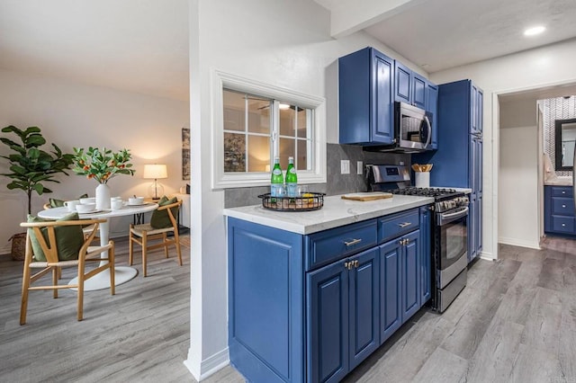 2929 Fire Mountain Dr Unit 9, Oceanside, CA 92054 - kitchen featuring stainless steel appliances, blue cabinets, light wood-style flooring, beamed ceiling, and light stone counters