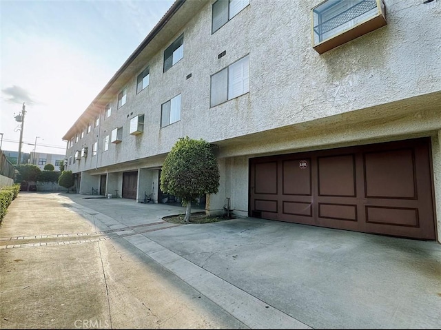 view of building exterior with driveway and a garage