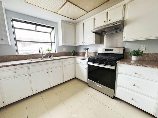 kitchen with stainless steel gas range, under cabinet range hood, a sink, and white cabinetry