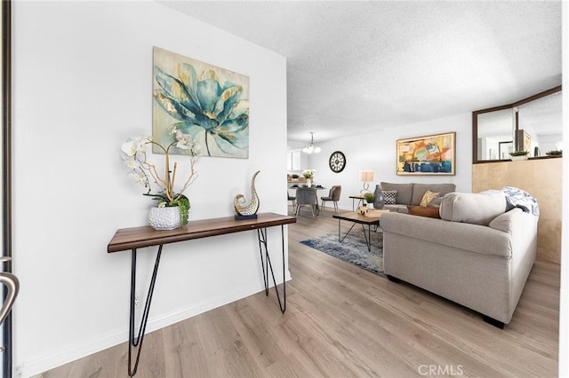 321 N Lincoln Ave Unit B, Monterey Park, CA 91755 - living room featuring a textured ceiling, light wood-type flooring, and a chandelier