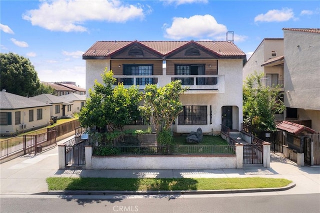 321 N Lincoln Ave Unit B, Monterey Park, CA 91755 - view of front of house with a tiled roof, a gate, a fenced front yard, stucco siding, and a balcony