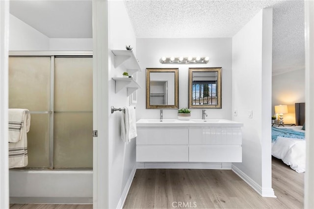 321 N Lincoln Ave Unit B, Monterey Park, CA 91755 - ensuite bathroom featuring wood finished floors, double vanity, a textured ceiling, and combined bath / shower with glass door