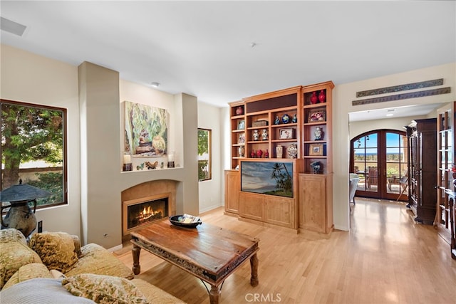 3805 Vista Azul, San Clemente, CA 92672 - living room featuring french doors, light wood-style flooring, a lit fireplace, and baseboards