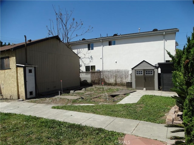 view of property exterior featuring a shed, an outdoor structure, and stucco siding