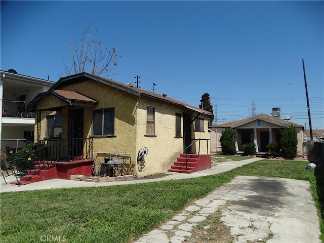 view of front of home featuring stucco siding and a front yard