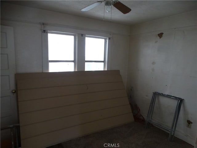carpeted spare room with a ceiling fan
