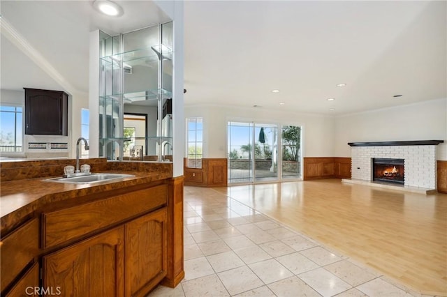 3808 E Summitridge Ln, Orange, CA 92867 - bathroom featuring a sink, wainscoting, a brick fireplace, tile patterned flooring, and ornamental molding
