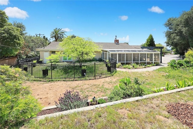 back of property with fence, a sunroom, and a chimney