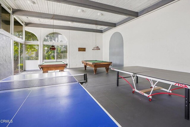 playroom featuring arched walkways, beam ceiling, finished concrete flooring, and billiards