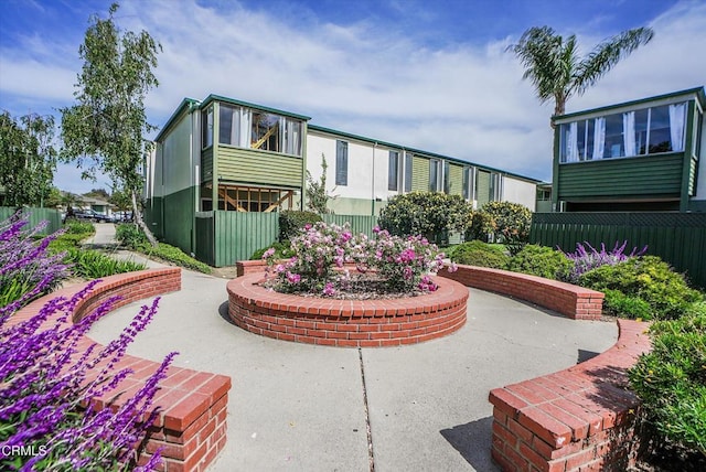 view of home's community with fence and a patio