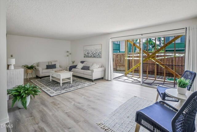 living area with a textured ceiling and wood finished floors
