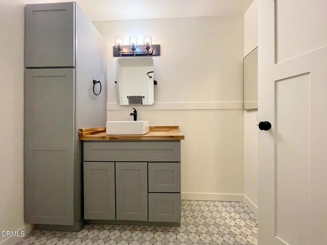 bathroom featuring tile patterned floors, baseboards, and vanity