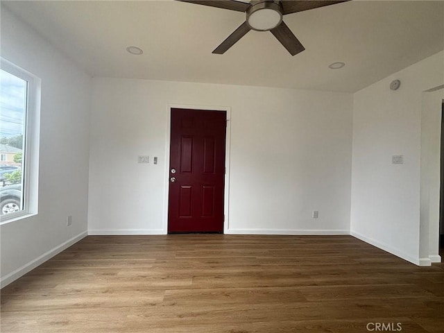 unfurnished room featuring a ceiling fan, wood finished floors, and baseboards