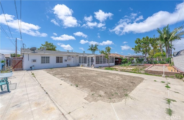 6371 Shawnee Rd, Westminster, CA 92683 - back of property with a patio area, a sunroom, a gate, and stucco siding