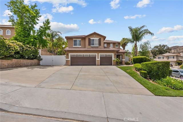 30463 Vineyard Ln, Castaic, CA 91384 - mediterranean / spanish home with an attached garage, driveway, a tile roof, stucco siding, and a gate
