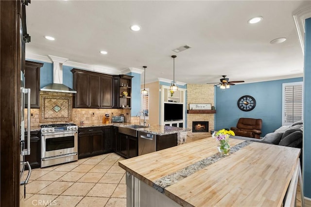 30463 Vineyard Ln, Castaic, CA 91384 - kitchen with stainless steel appliances, wall chimney exhaust hood, open floor plan, a sink, and crown molding