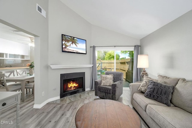 14886 Reedley St Unit A, Moorpark, CA 93021 - living area featuring light wood-style floors, a warm lit fireplace, high vaulted ceiling, and a ceiling fan
