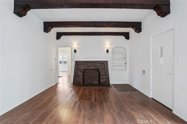 4235 Garthwaite Ave, Los Angeles, CA 90008 - unfurnished living room with wood finished floors, built in shelves, baseboards, a stone fireplace, and beam ceiling