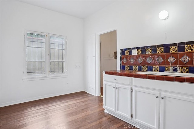 4235 Garthwaite Ave, Los Angeles, CA 90008 - kitchen featuring tile counters, white cabinets, dark wood-style floors, and baseboards