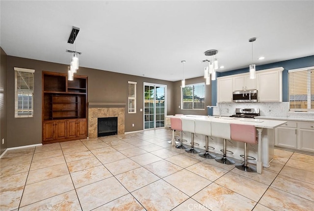 14271 Blackstone St, Hesperia, CA 92345 - kitchen featuring appliances with stainless steel finishes, light tile patterned floors, decorative backsplash, white cabinetry, and recessed lighting