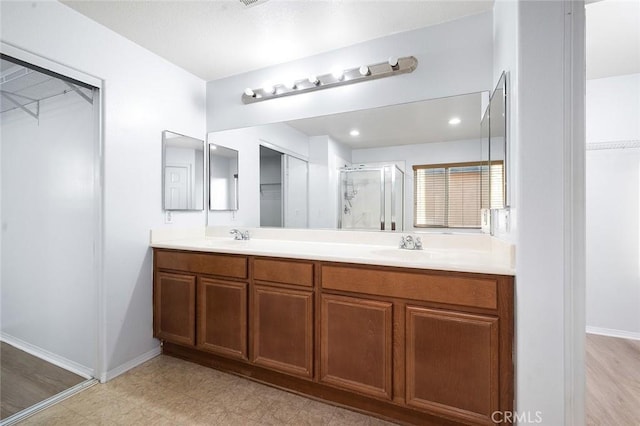 14271 Blackstone St, Hesperia, CA 92345 - bathroom with a stall shower, baseboards, double vanity, and a spacious closet