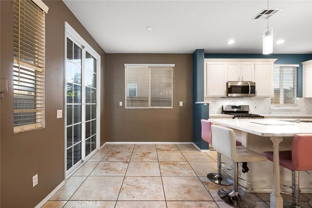 14271 Blackstone St, Hesperia, CA 92345 - kitchen with appliances with stainless steel finishes, decorative backsplash, healthy amount of natural light, white cabinets, and recessed lighting