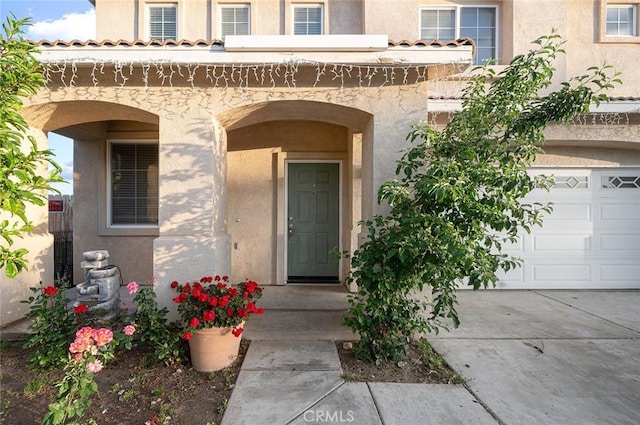 14271 Blackstone St, Hesperia, CA 92345 - view of exterior entry featuring stucco siding, a garage, and concrete driveway