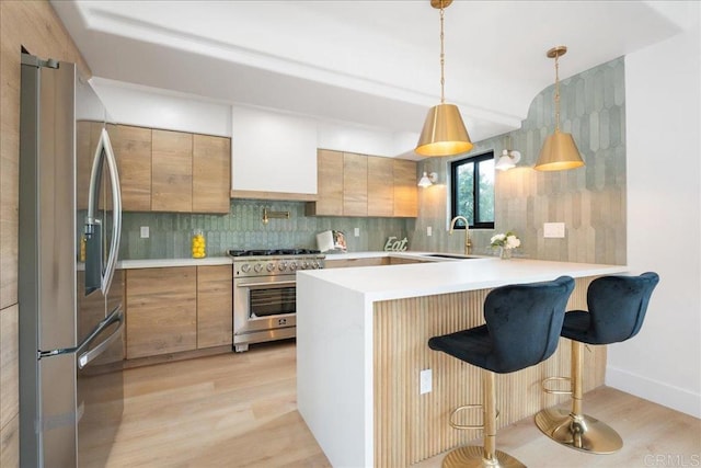 2464 Haller St, San Diego, CA 92104 - kitchen featuring stainless steel appliances, a sink, light wood finished floors, a peninsula, and light countertops