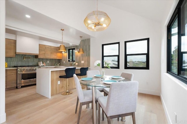 2464 Haller St, San Diego, CA 92104 - dining space with plenty of natural light, light wood finished floors, a chandelier, baseboards, and vaulted ceiling