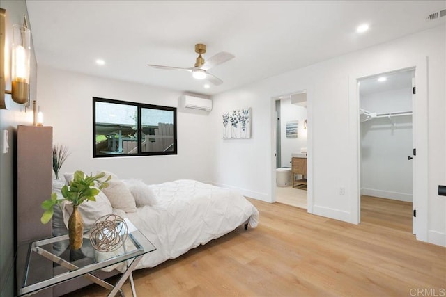 2464 Haller St, San Diego, CA 92104 - bedroom featuring a wall unit AC, light wood-style floors, a spacious closet, connected bathroom, and recessed lighting