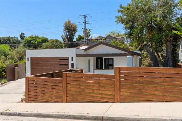 2464 Haller St, San Diego, CA 92104 - view of front of house with a fenced front yard, stucco siding, an attached garage, and driveway