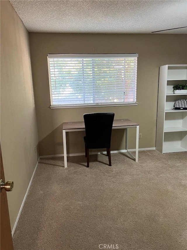 home office featuring carpet, a textured ceiling, and baseboards