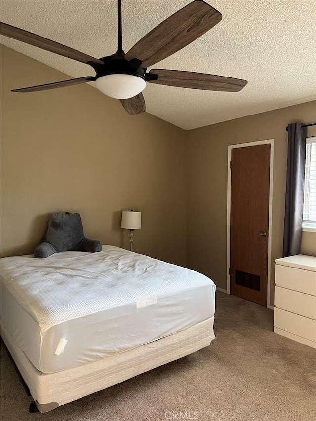 carpeted bedroom featuring a textured ceiling and a ceiling fan
