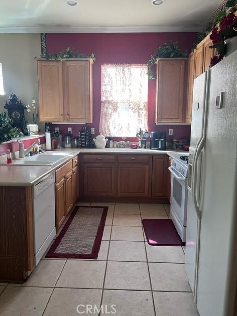 5001 Rolling Hls, Banning, CA 92220 - kitchen featuring white appliances, a sink, light tile patterned floors, light countertops, and ornamental molding