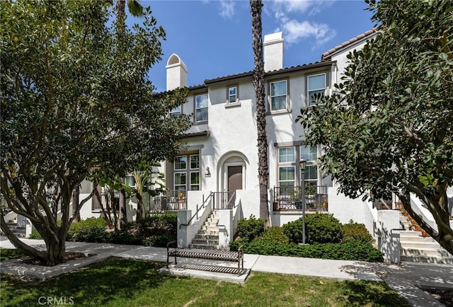 68 Webber Way, Buena Park, CA 90621 - townhome / multi-family property featuring a chimney, stucco siding, stairway, and a tiled roof